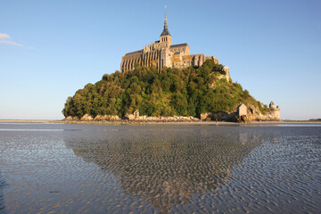 view of famous Le Mont Saint-Michel tidal island in beautiful twilight during blue hour at dusk, Normandy, France