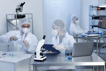 Scientists in protective suits working at laboratory