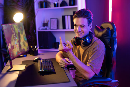 Host channel concentrated smart gaming streamer playing the fighting Moba on computer screen with muptiplayers or single at battle arena . Esport live streaming at neon digital light room. Pecuniary.