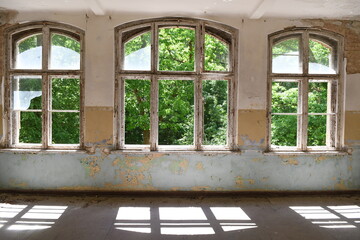 Sonne scheint hinein in Drei Bogenfenster in marodem Altbau mit Schatten der Fenster 