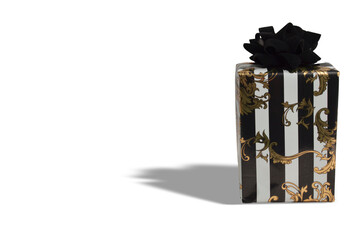 Elegant gift box with black and gold wrapping paper and bow on white background