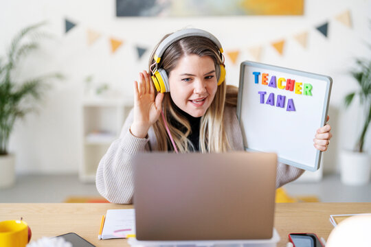 Teacher Tana is teaching online. She's using a whiteboard and headphones to connect with her students remotely, ensuring learning continues.