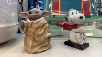 Naklejka premium Guayaquil, Ecuador – May 17, 2025: Decorative figures of Grogu (Baby Yoda) and Snoopy on display at a gift shop. Editorial use only.