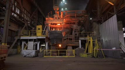 Molten metal pouring from furnace in steel mill. Stock clip - Powered by Adobe