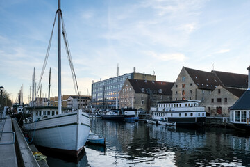 Fototapeta premium Copenhagen – View of Christianshavn Canal, lined with moored boats and colorful houses, reflecting the charm of this picturesque historic neighborhood.