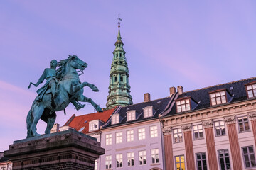 Naklejka premium Copenhagen, Denmark – View of statue of Bishop Absalon, founder of Copenhagen, with Nikolaj Kunsthal, a former church now hosting contemporary art, in the background.