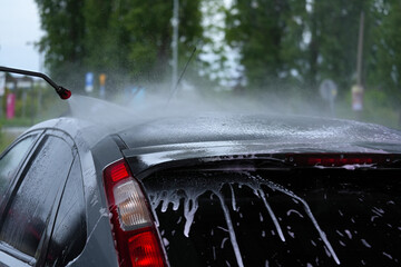 Contact-free outdoor car wash by water jet outdoors.