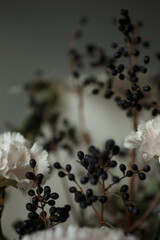 Close-up of black berries and soft pastel flowers with creamy white petals. Elegant autumn composition perfect for wedding design, greeting cards, branding, and floral backgrounds.