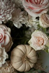 Top view of pastel pink roses, white chrysanthemums, and a small beige pumpkin. Romantic floral composition perfect for autumn wedding invitations, seasonal greeting cards, or branding.