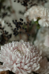 Close-up of black berries and soft pastel flowers with creamy white petals. Elegant autumn composition perfect for wedding design, greeting cards, branding, and floral backgrounds.