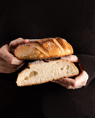 Pão cortado com mãos segurando