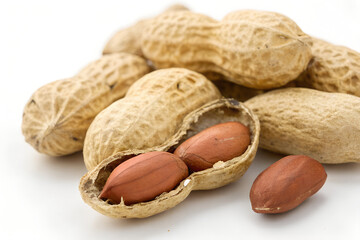 Close-up of peanuts in shells one open to reveal the nuts isolated on white background