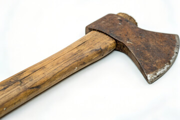 A close-up shot of an old, rusty axe with a wooden handle against a white background.