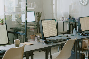 Office setup featuring workstations with computer monitors, keyboards, and various desk accessories. Crisp and clean environment emphasizing productivity and organization