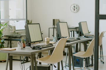 Modern office space showcasing several desks with computer screens and office supplies, creating professional work environment perfect for productivity and collaboration