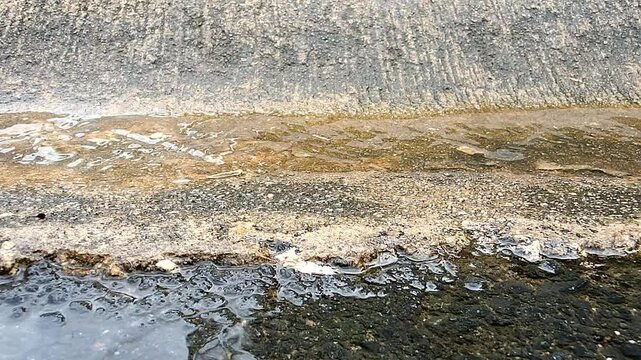 Agua pasando por el cemento, directo a la alcantarilla. 