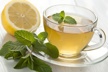 Cup of Herbal Tea with Lemon and Fresh Mint on White Table