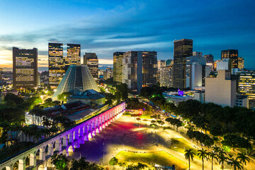 Lapa Aqueduct Illuminated With Purple and Pink Colors in the Evening With Tall Office Buildings of Rio de Janeiro Downtown