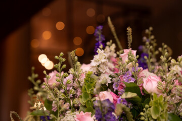arreglo floral con diversidad de flores y fondo con bokeh de un evento elegante