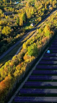 Aerial view of Joni&scaron;kis captures a vibrant autumn landscape blending with solar farm and railway track