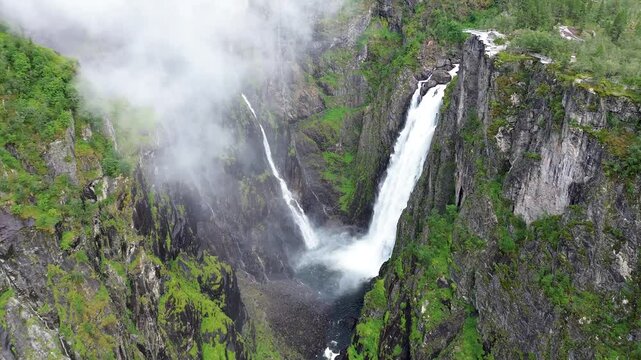 voringsfossen waterfall on mossy mountain with mist in Hardangervidda National park in Norway
