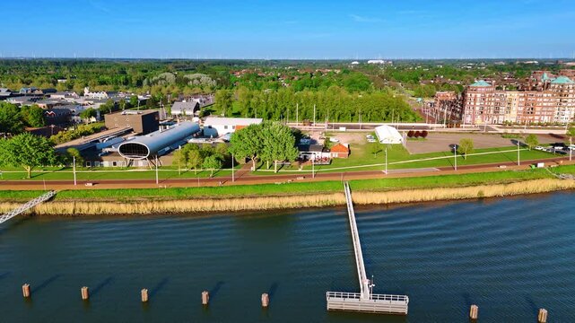 Green waterfront of beautiful Lelystad, the Netherlands. Drone footage above the waterscape of lake Markermeer revealing view on the port.