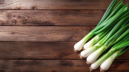A collection of vibrant green onions showcasing their crisp green tops and white bulbs, resting on a rustic wooden surface with a warm tone and texture.