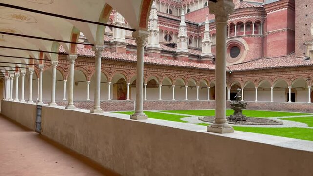 Cloister of the Charterhouse of Pavia, Italy, featuring Renaissance arcades, frescoed ceilings, a central fountain, and detailed Gothic-Renaissance architecture