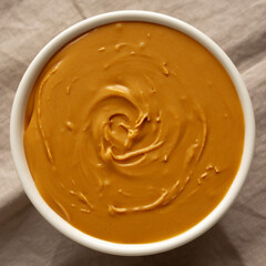 Organic Peanut Butter in a Bowl, top view. Flat lay, overhead.