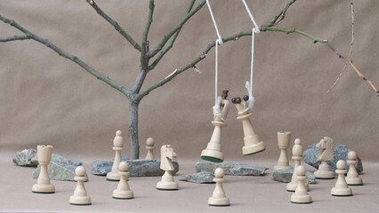 chess pieces white king and queen hanging on noose among other white chess pieces