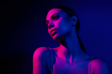 Elegant image of a young woman posing with neon blue and pink light creating a glamorous nightclub...