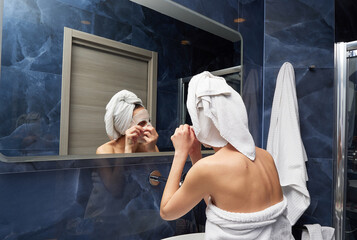 Woman put face mask at bathroom