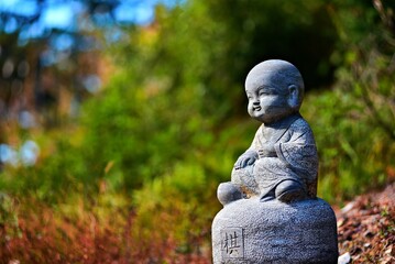 Adorable stone sculpture of a child monk in Nuona Pagoda Temple, aka Small Heavenly Pool Temple, a Tibetan Temple in Lushan (Mount Lu), Jiujiang City, Jiangxi, China