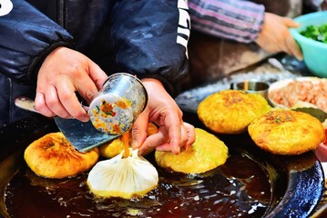 Filling a dumpling with egg batter as it is fried, Song Yuan market, Quzhou City, Zhejiang Province, China
