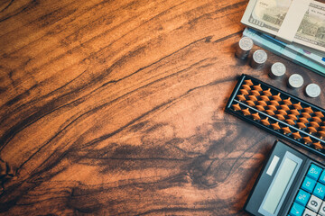 Business concept. Detailed View of a Wooden Workspace Featuring Currency, Coins, Calculator, and...