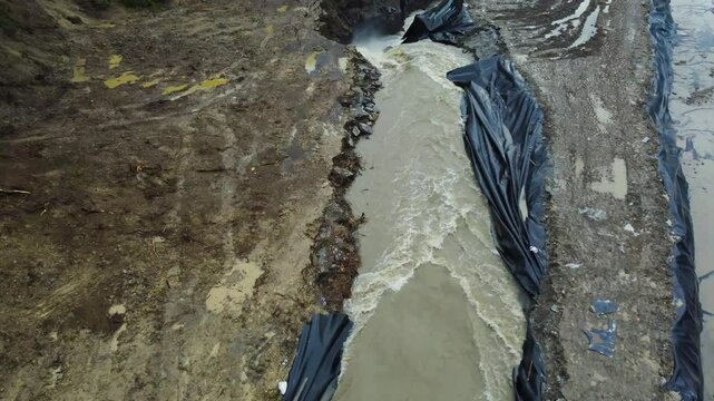 Aerial footage of the place where the Corund River enters the salt mine in Praid, Harghita County - Romania. The hole where the water floods into the Praid salt mine
