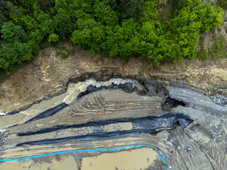 Aerial view of the hole where the ground collapsed, spreading the water of the Corund River into the Praid salt mine. Flooding of the Praid salt mine - Romania