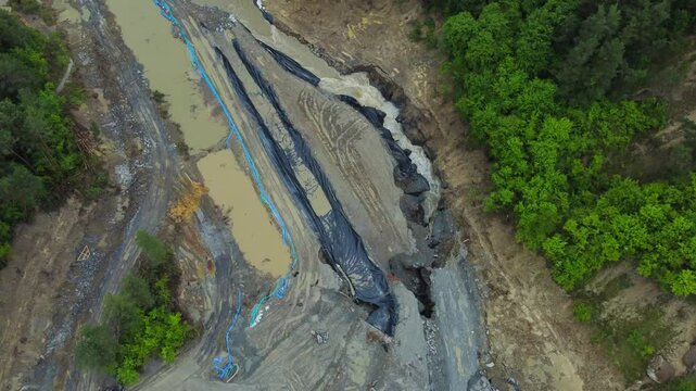 Aerial footage of the place where the Corund River enters the salt mine in Praid, Harghita County - Romania. The hole where the water floods into the Praid salt mine