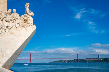 View of Monument to the Discoveries (Padrao dos Descobrimentos) and 25 April Bridge on a sunny day, Lisbon, Portugal, Europe