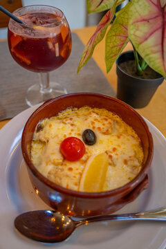 View of glass of Sangria and Bacalhau Com Natas traditional Portuguese dish in restaurant, Alfama District, Lisbon, Portugal, Europe