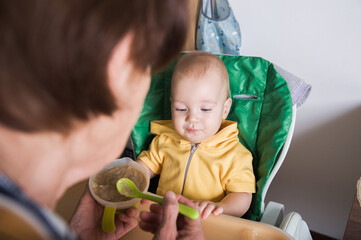 Happy Baby Being Fed by Grandmother at Home