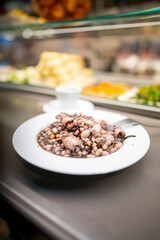 Delicious Pulpo y alubias at food court in Barcelona during spring season