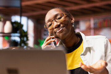 Upbeat woman having friendly conversation with friends during telephone call using smartphone....