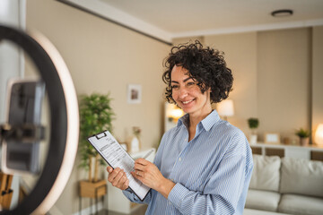 Small business female owner hold a clipboard and record live stream