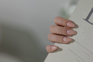 Glamorous beige almond nails, elegant gel manicure close-up with soft lighting and luxury vibe