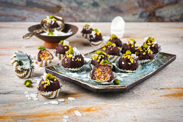 Artisan handcrafted homemade fine dark chocolate pralines with pistachio and coconut chips served...