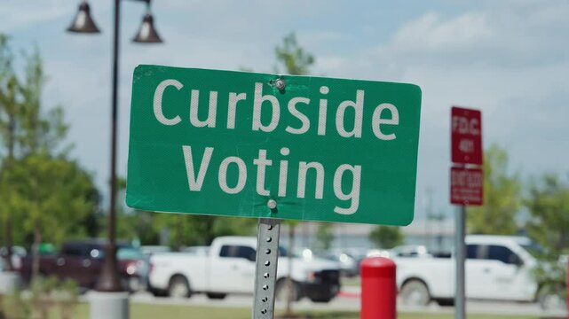 Curbside Voting Road Sign with Cars in the Background