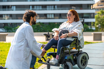 Doctor assisting happy disabled woman in electric wheelchair in park