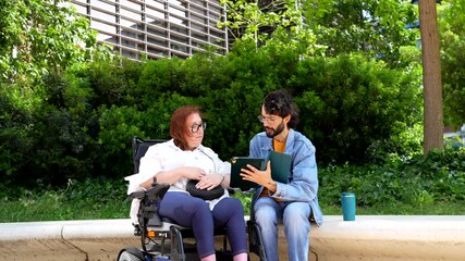 Social worker assisting a woman in a wheelchair, discussing important matters in a park setting - Powered by Adobe