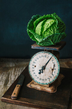 Savoy cabbage on top of a vintage kitchen scale 